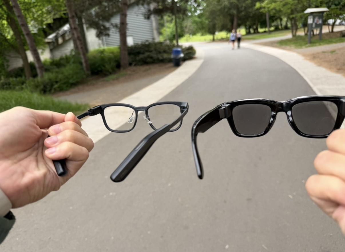 Comparing Meta Display and MemoMind One smart glasses outdoors.