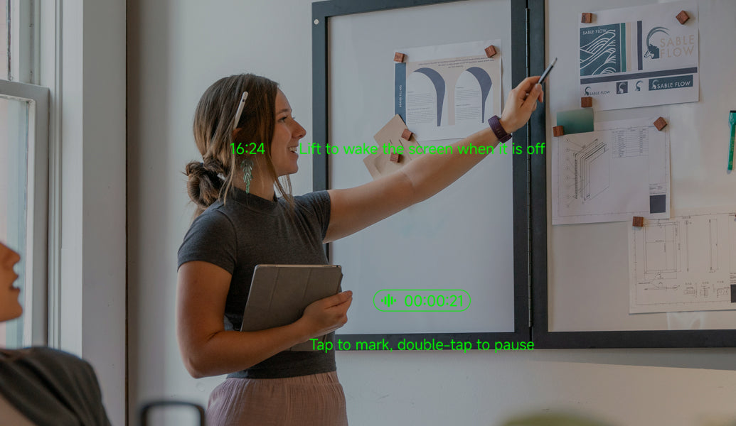 A speaker interacting with MemoMind AI glasses during a presentation.